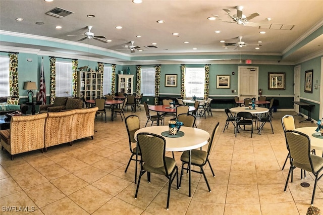 tiled dining area with ceiling fan, a tray ceiling, and crown molding