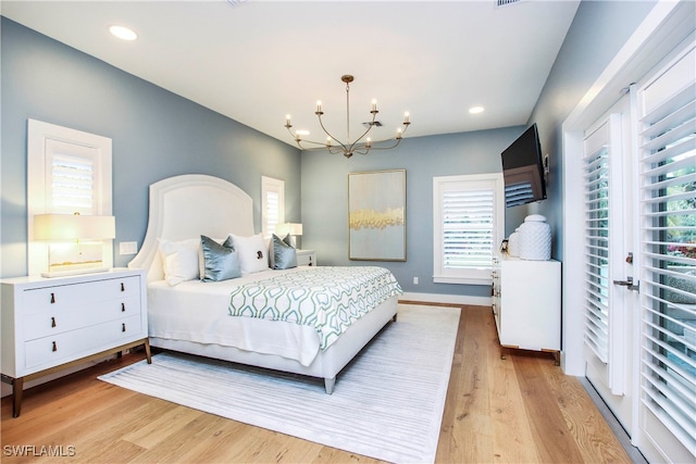 bedroom with a chandelier and light hardwood / wood-style floors