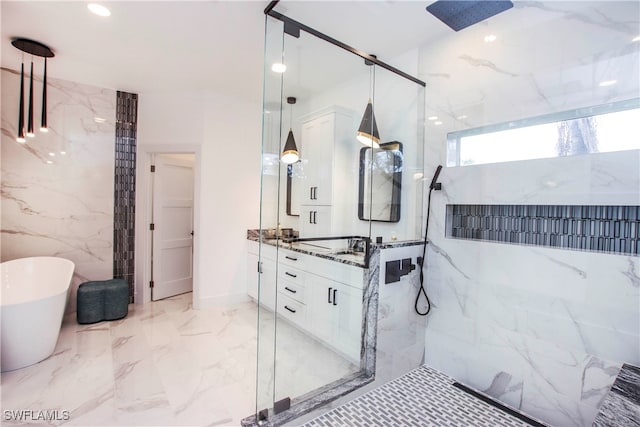 bathroom with tile walls, vanity, and separate shower and tub