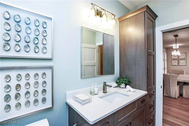 bathroom featuring vanity, a chandelier, and hardwood / wood-style floors