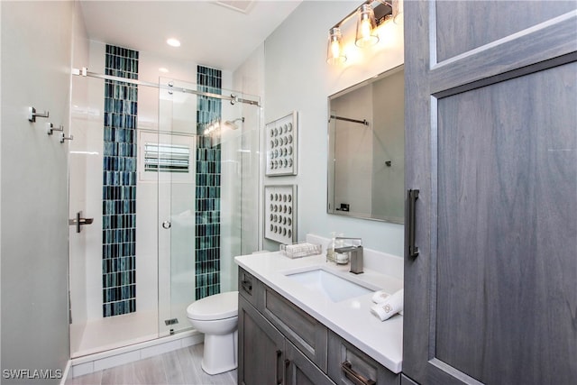 bathroom with vanity, toilet, and an enclosed shower