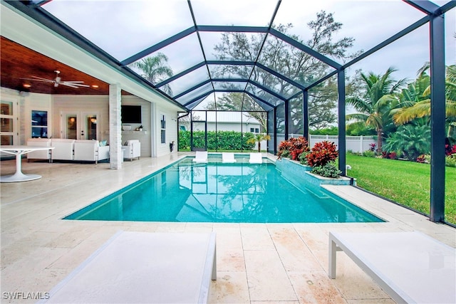 view of pool with ceiling fan, glass enclosure, and a patio