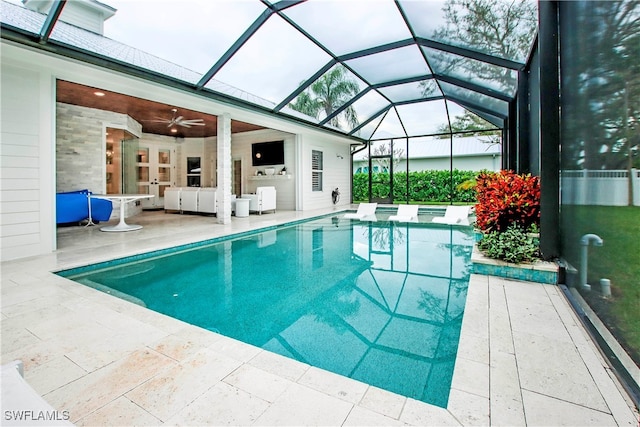 view of swimming pool with ceiling fan, a patio, and a lanai