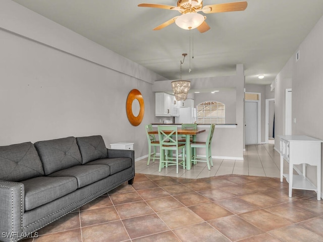 tiled living room with ceiling fan with notable chandelier