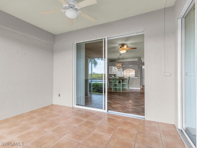 tiled empty room featuring ceiling fan