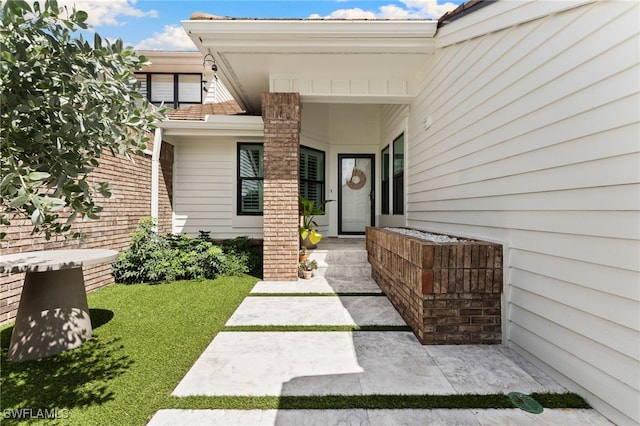 property entrance with a lawn