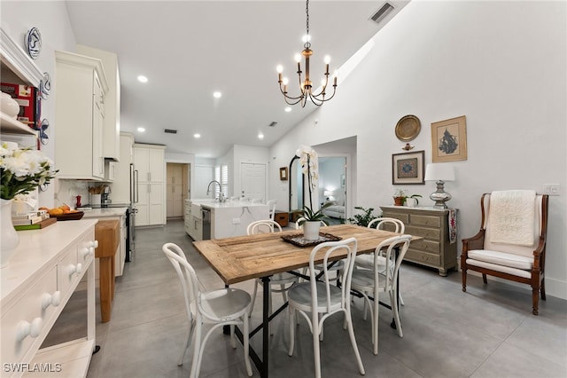 dining room with sink, vaulted ceiling, and a notable chandelier