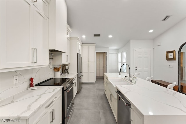kitchen with visible vents, a center island with sink, high quality appliances, recessed lighting, and a sink