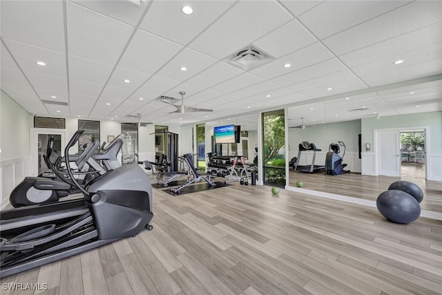 workout area featuring light hardwood / wood-style flooring and a drop ceiling