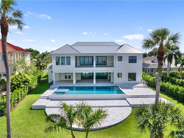 back of house with a yard, a patio area, and a balcony