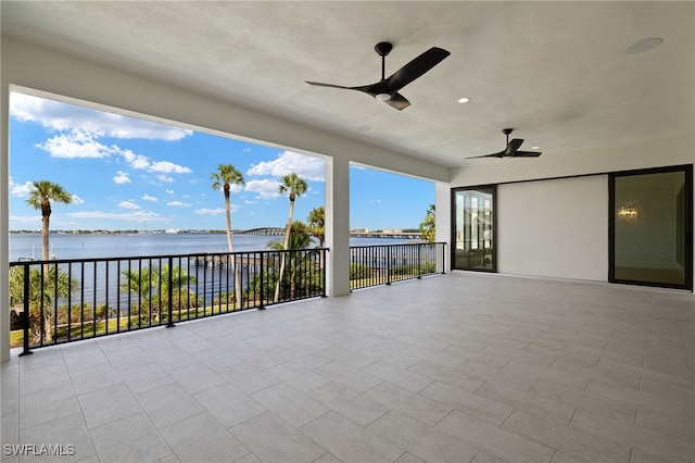 view of patio / terrace with a water view, ceiling fan, and a balcony