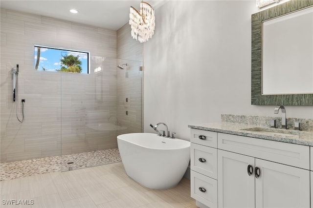 bathroom with vanity, an inviting chandelier, and plus walk in shower