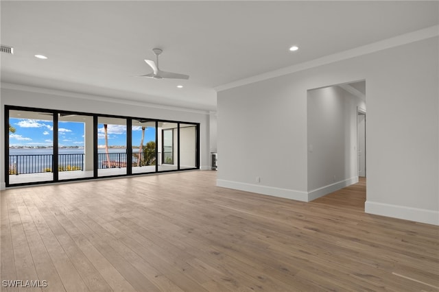 empty room with a water view, ceiling fan, ornamental molding, and light hardwood / wood-style flooring