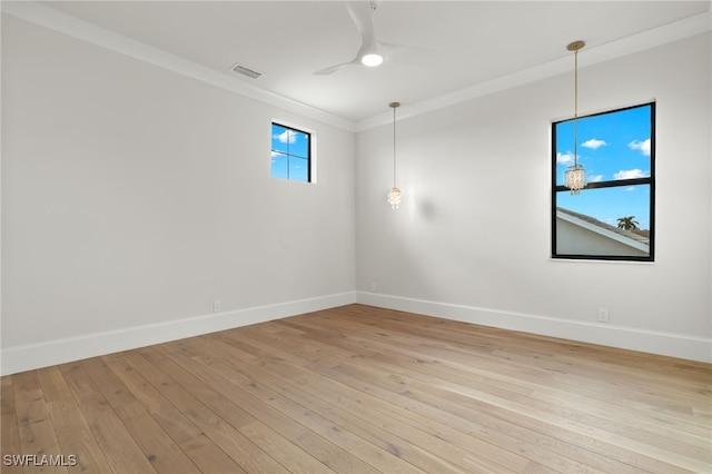 spare room featuring crown molding, light wood-type flooring, and ceiling fan