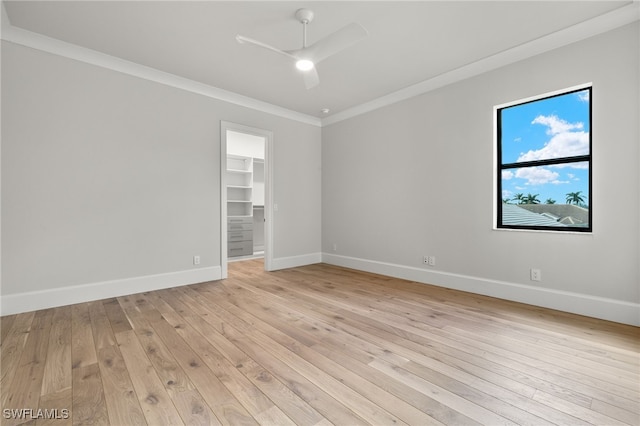 spare room featuring crown molding, light wood-type flooring, and ceiling fan