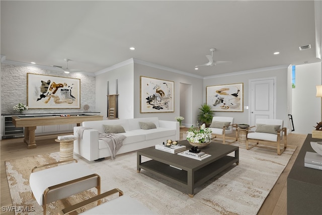 living room with light hardwood / wood-style flooring, ornamental molding, and ceiling fan