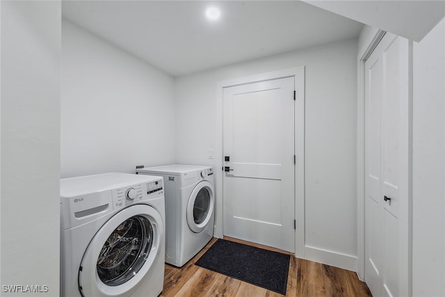 washroom with separate washer and dryer and light wood-type flooring