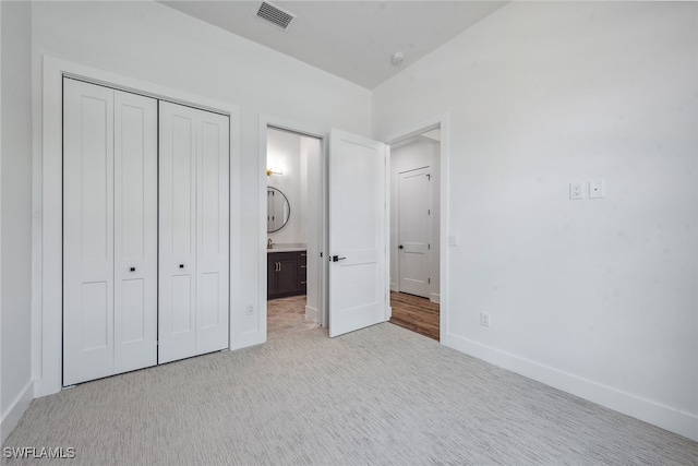 unfurnished bedroom featuring light carpet and a closet