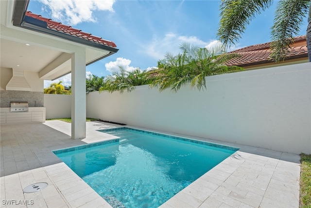 view of pool featuring area for grilling, exterior kitchen, and a patio area