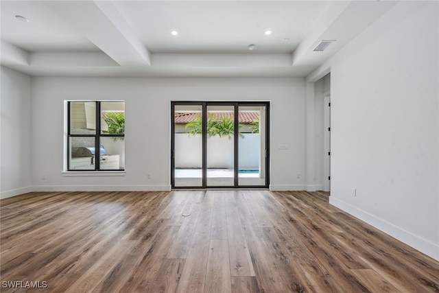 unfurnished room featuring a wealth of natural light and hardwood / wood-style floors