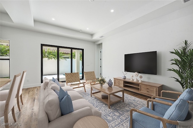 living room featuring hardwood / wood-style floors and a raised ceiling