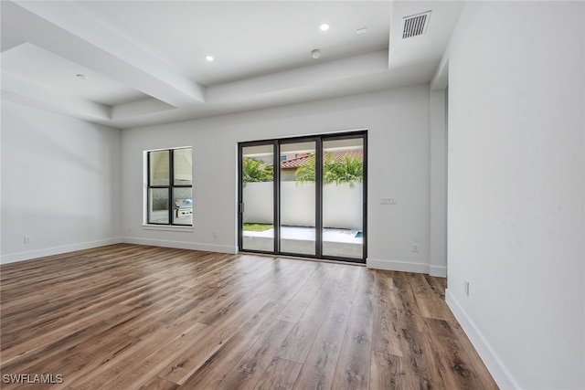 spare room featuring hardwood / wood-style floors and a tray ceiling