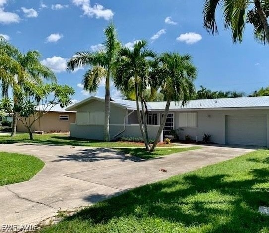 ranch-style house with a garage and a front lawn