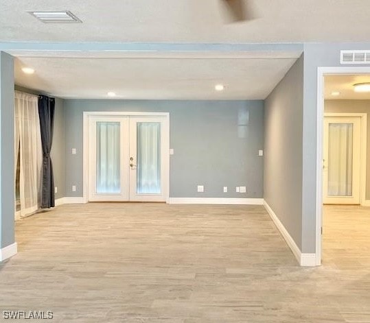 spare room with french doors and light wood-type flooring