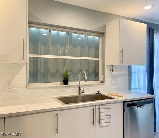 kitchen featuring white cabinetry, tasteful backsplash, sink, and stainless steel dishwasher