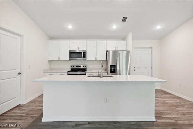 kitchen featuring an island with sink, white cabinets, wood-type flooring, and appliances with stainless steel finishes