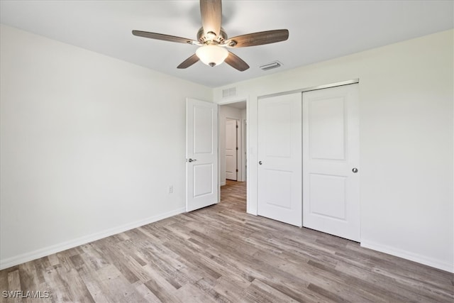 unfurnished bedroom featuring ceiling fan, light hardwood / wood-style flooring, and a closet