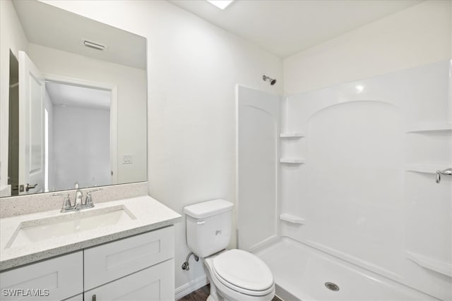 bathroom featuring walk in shower, vanity, and toilet