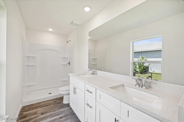 bathroom with vanity, a shower, hardwood / wood-style floors, and toilet