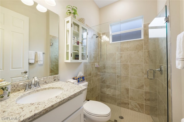 bathroom with vanity, toilet, and a shower with door