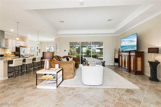 living room with a tray ceiling, light tile patterned floors, and ornamental molding