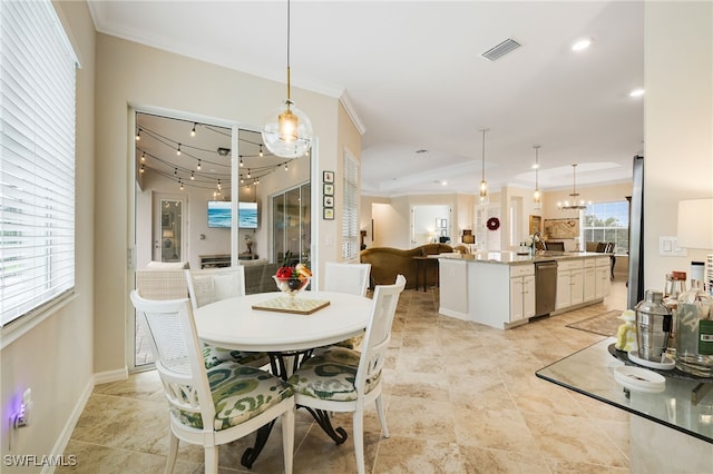 dining room featuring a notable chandelier, ornamental molding, and sink