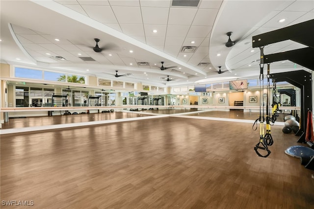 exercise room with a paneled ceiling and wood-type flooring