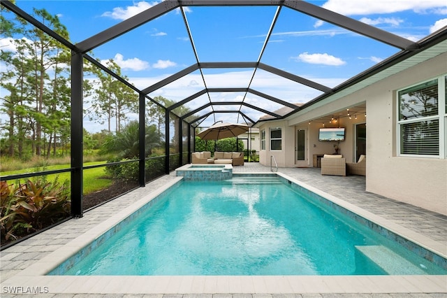 view of pool with an outdoor living space, glass enclosure, ceiling fan, an in ground hot tub, and a patio area