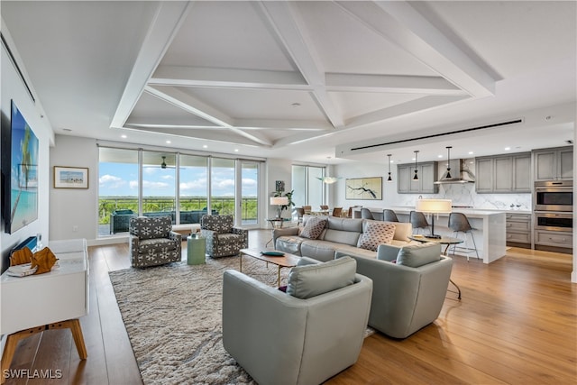 living room with light hardwood / wood-style floors, beam ceiling, and coffered ceiling