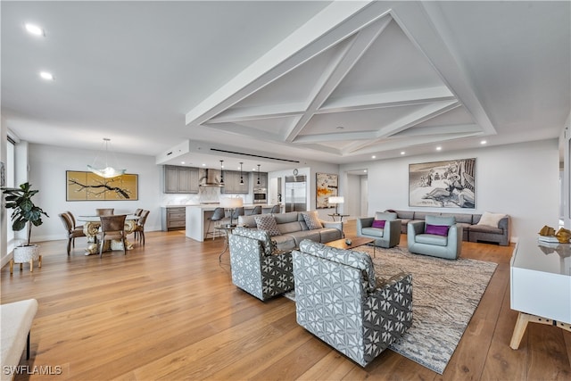 living room with beamed ceiling, coffered ceiling, and light hardwood / wood-style flooring