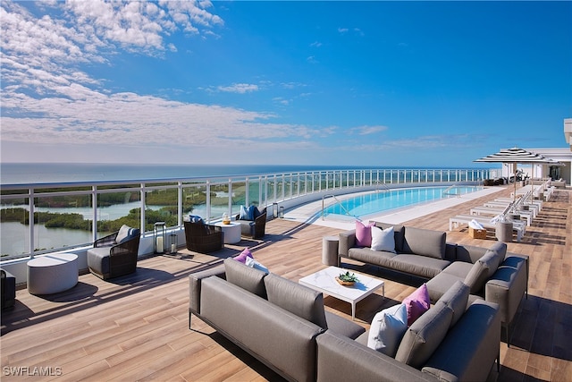 wooden deck with outdoor lounge area and a water view