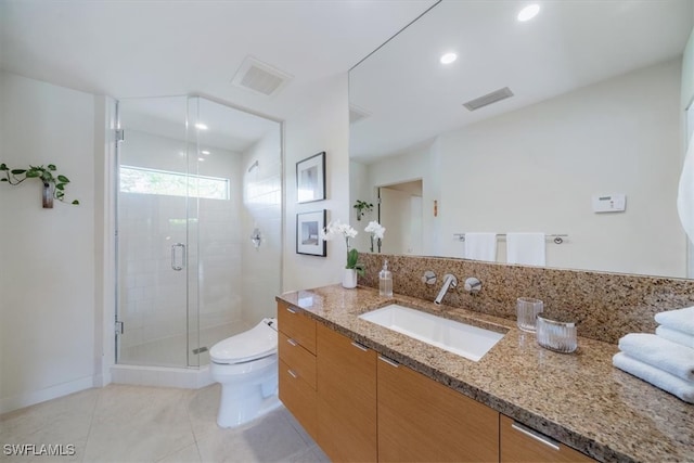 bathroom with tile patterned flooring, vanity, toilet, and a shower with shower door