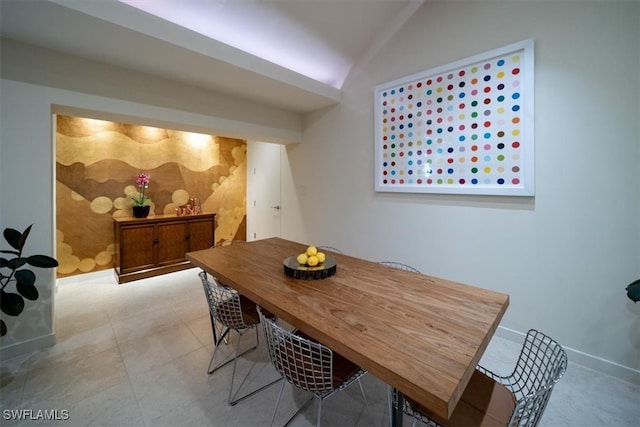 tiled dining room featuring vaulted ceiling