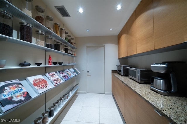 interior space with light stone countertops and light tile patterned flooring