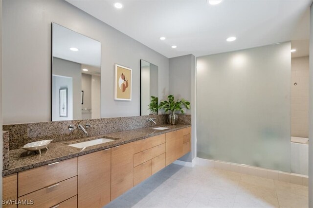 bathroom with walk in shower, vanity, and tile patterned floors