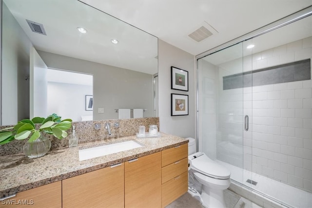 bathroom featuring vanity, toilet, and an enclosed shower