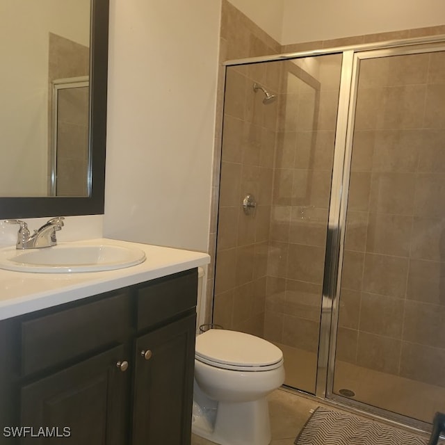 bathroom featuring vanity, a shower with shower door, toilet, and tile patterned floors