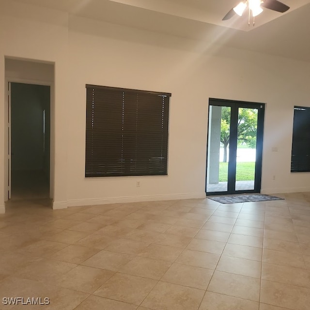 tiled spare room featuring ceiling fan