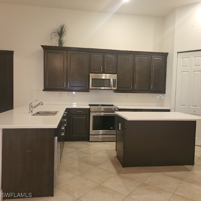 kitchen featuring dark brown cabinets, sink, light tile patterned floors, and stainless steel appliances