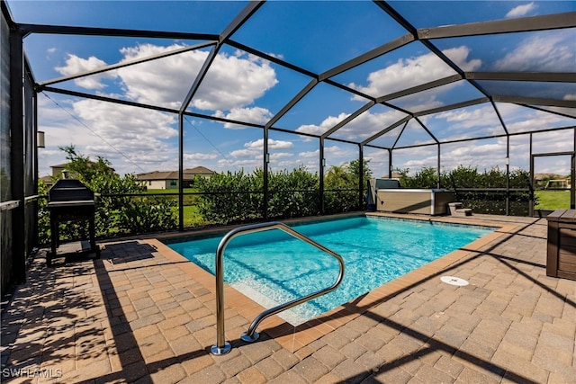 view of swimming pool with glass enclosure, a grill, and a patio area